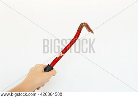 Close-up Of Red Metal Nail Puller In Hand Isolated On White Background.