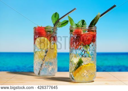 Hard Seltzer, Blue Sea On Background. Two Summer Cocktails On The Beach. Refreshing Summer Drinks, B