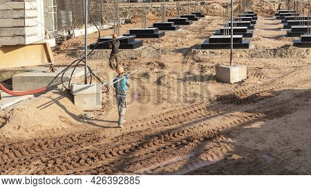 A Worker Transfers Elements For The Installation Of The Formwork At The Construction Site. Monolithi