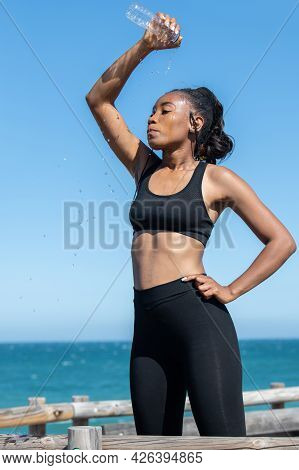 Tired Latin American Woman Refreshing Herself With Water After Exercising: Health Concept.