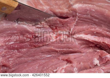Slice The Pork Or Beef With A Knife On The Table In Close-up.preparation Of Meat Dishes And Food Pro