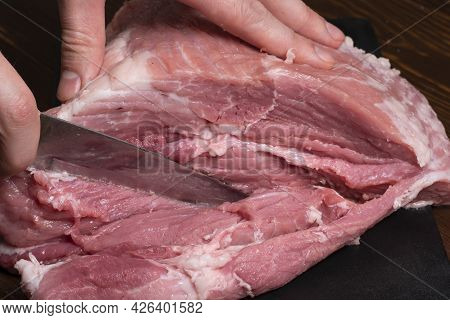 Slice The Pork Or Beef With A Knife On The Table In Close-up.preparation Of Meat Dishes And Food Pro