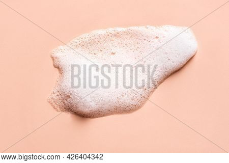 Face Cleansing Mousse Sample. White Cleanser Foam Bubbles On Nude Background. Soap, Shower Gel, Sham