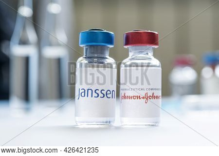 A Vaccination Syringe And A Glass Ampoule With A Clear Liquid On A Blue Background With The Logo Of 