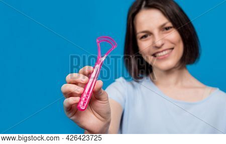 Beautiful Happy Young Woman With Tongue Scraper On Blank Blue Background