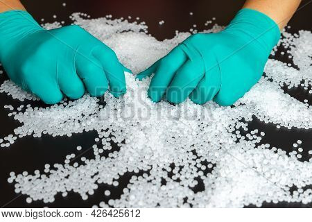 Plastic Beads On Green Gloved Hand. Polymer Beads. The World's Plastic Reduction Policy. Plastic On