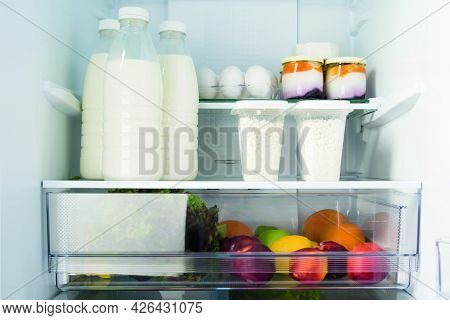 Dairy Products And Fruits Are On The Shelf In Refrigerators, Close-up Front View