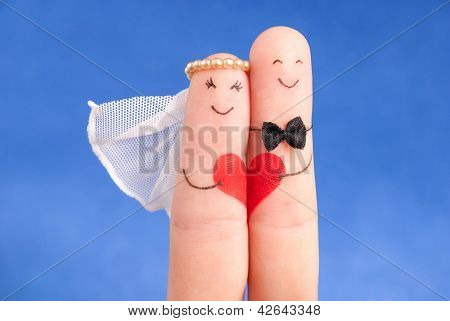 Wedding Concept -  Newlyweds Painted At Fingers Against Blue Sky