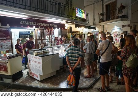 Peschici - 29/06/2021: Famous Italian Ice Cream Shop With People In Peschici At Night , Puglia, Ital