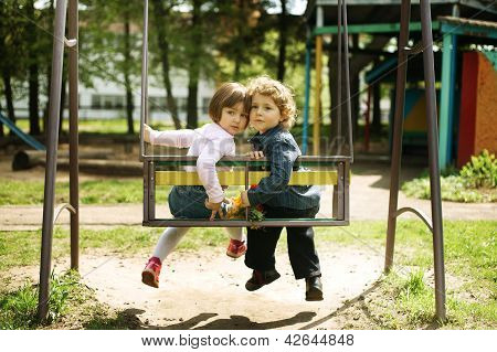 boy and girl on the swings