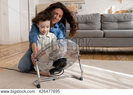 Parent And Kid At Home: Cheerful Young Mum With Small Son Enjoy Propeller Fan Indoors. Single Mother