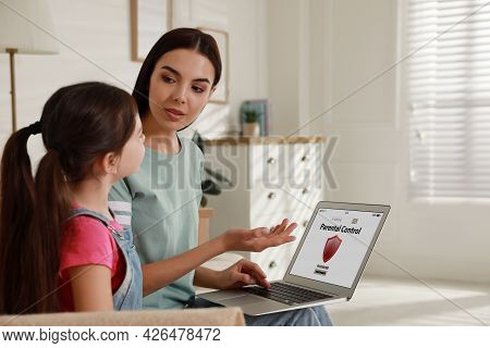 Mother Installing Parental Control App On Laptop To Ensure Her Child's Safety At Home