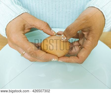 The Hands Of An Unrecognizable Woman Peel A Boiled Egg