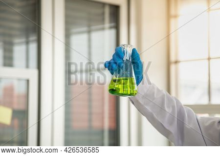 Science And Healthcare Concept. Closeup Of Docter Scientists Hand Holding Green Liquid Chemicals Fla