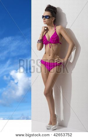 美女着比基尼和放在臀部上的手