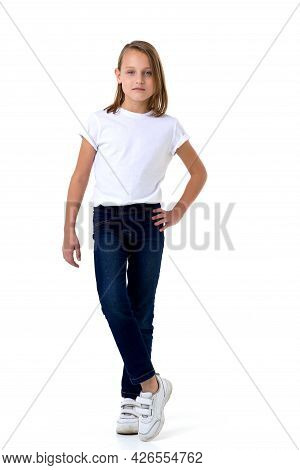 Blonde In A White T-shirt. Pretty Stylish Girl Posing In Studio On A White Background. Full-length P