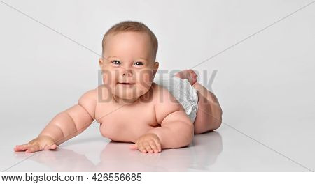 Happy Portrait Six Month Old Baby Girl In A Diaper Lying Looking At You, Arms Outstretched To The Si