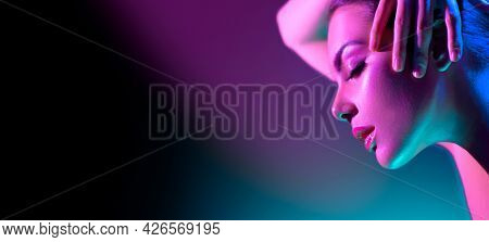 High Fashion model woman in colorful bright neon lights posing in studio, night club. Portrait of beautiful girl in UV. Art design colorful make up. On colourful vivid background, art design