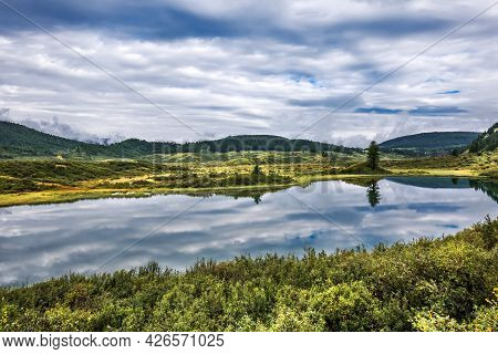 A Small Mountain Lake Surrounded By Mountains And Coniferous Taiga. Ulagan District Of The Altai Rep