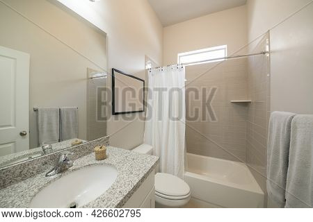 Bathroom Interior With Vanity And Tub With Light Brown Rectangular Wall Tiles And Window