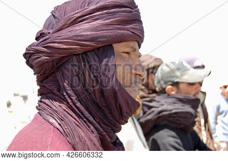 Waw Al Kabir, Libya - March 29, 2006: A Tuareg Driver Wearing Traditional Robes To Cope With The Sun