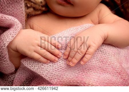 Newborn Baby In A Pink Plaid. Tiny Hands, Fingers.