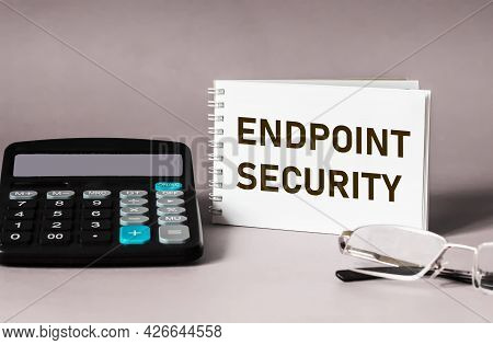 The Endpoint Security Text Is Written On A Notepad With Glasses And A Calculator On A Gray Backgroun
