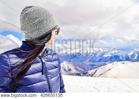 Caucasian Female Person Enjoy Winter Mountains Panorama In Sunny Ski Resort. Right Empty Blank Space