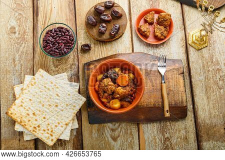 Jewish Dish Shuttle With Meat In A Clay Dish On A Wooden Table Near Matzo And Ingredients. Horizonta