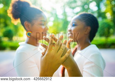 Brazilian Lesbian Couple In White Dress Spending Time Together Celebrating Engagement In Summer Park