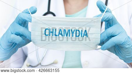 The Doctor Holds A Disposable Mask With The Text Chlamydia