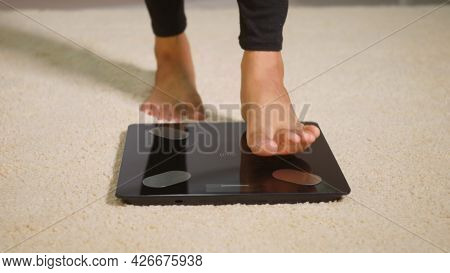 Asian Young Woman Leg Stepping Standing On Floor Electric Scales, Female Working Out At Home In Livi