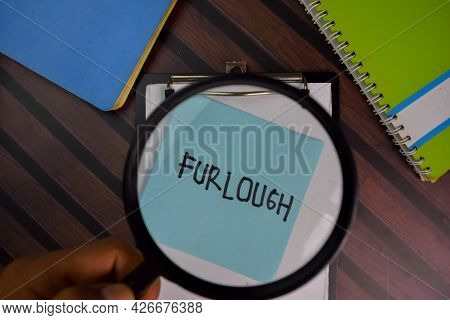 Furlough Write On Sticky Notes With Magnifying Glass Isolated On Office Desk