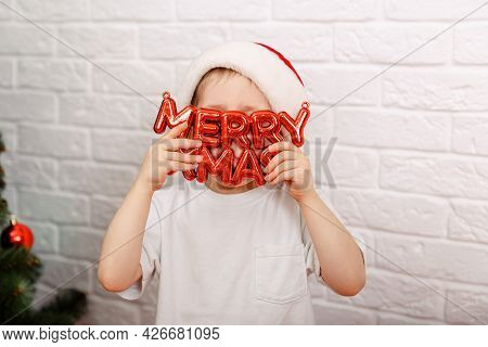 Funny Child Holding Board With Inscription Merry Xmas. The Boy Hold An Inscription Merry Cristmas. C