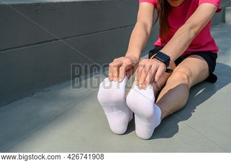 Runner Woman Trying To Do Foot Stretching For Prevent Injuries. The Benifit Of Stretching Can Increa