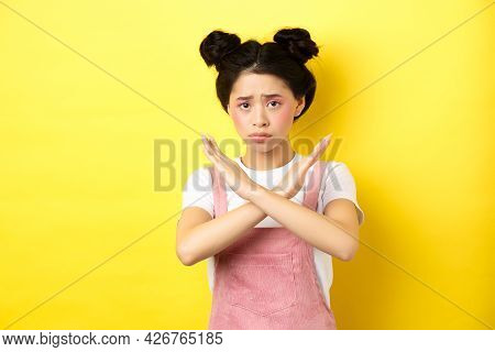 Sad Girl Begging To Stop, Frowning Uspet And Showing Cross Sign, Say No, Standing Gloomy On Yellow B