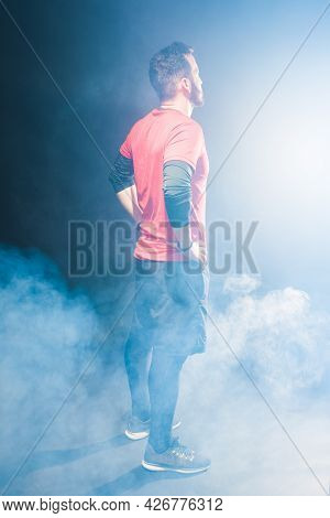 Side Back View Of An Adult Male With Hands In Waist Looking Forward.