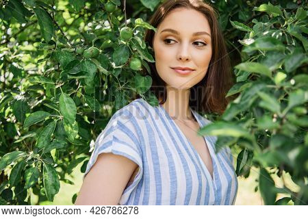 Pretty Woman Standing Near Tree Branches Outdoors