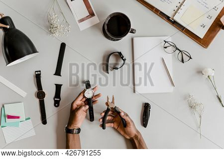 Horologist fixing a watch with pliers