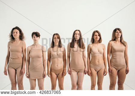 Several Girls With Different Physiques. Women In Beige Underwear. Different Height And Weight In Wom