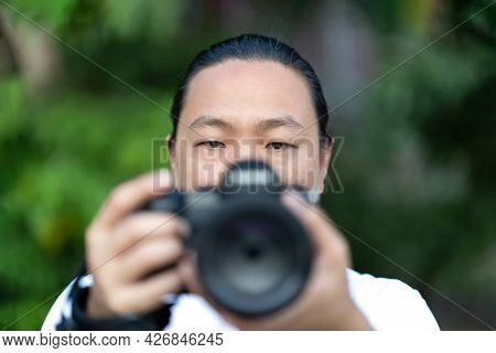 Focus On The Asian Man Face That He Holds The Blur Medium Format Camera In His Hand And Prepare To S