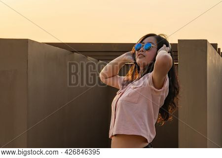 Asian Glasses Long Hair Girl Is Dancing On The Rooftop Of The Building In Twilight Sunset Time.