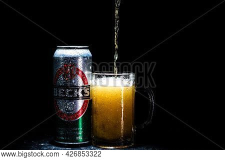 Can Of Beck`s Or Becks Beer And Beer Glass On Dark Background. Illustrative Editorial Photo Shot In 