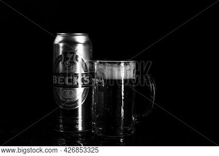 Can Of Beck`s Or Becks Beer And Beer Glass On Dark Background. Illustrative Editorial Photo Shot In 