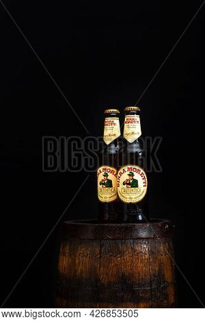 Bottle Of Birra Moretti Beer On Wooden Barrel With Dark Background. Illustrative Editorial Photo Buc