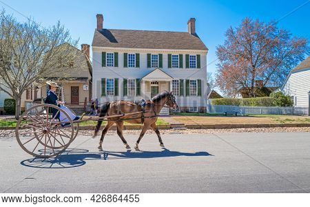 Williamsburg, Virginia, USA: 31st March 2021; Woman riding on a horse and buggy in colonial Williamsburg