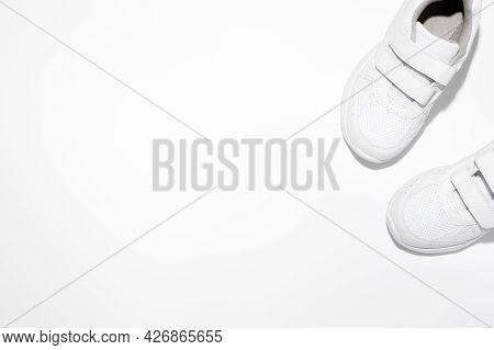 Mock Up Two White Childrens Sneakers With Velcro Fasteners With Copy Space Isolated On A White Backg