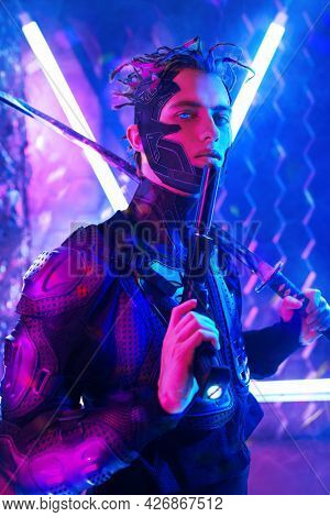 A brave sci-fi cyborg samurai man in a protective suit fights with sword and a gun in his hands in neon light. Cyberworld. Game, virtual reality.