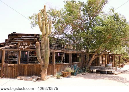July 14, 2021 In Pioneertown, Ca:  Wooden Buildings Besides Saguero Cactus And Cottonwood Trees Take