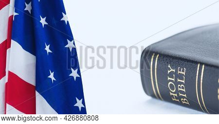 Digitally generated image of american flag and bible against white background. american independence day celebration concept